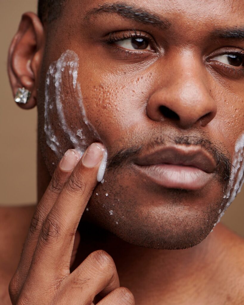 Man applying face wash in the mirror – beginner skincare step